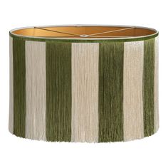 a green and white lamp shade with fringe trim