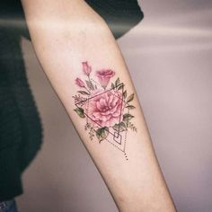 a woman's arm with pink flowers and geometric shapes on the left inner forearm