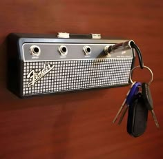 a guitar amplifier with keys hanging from it's front end and attached to the wall