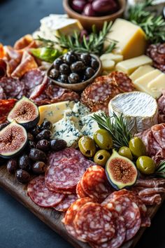 an assortment of meats, cheese and olives on a cutting board