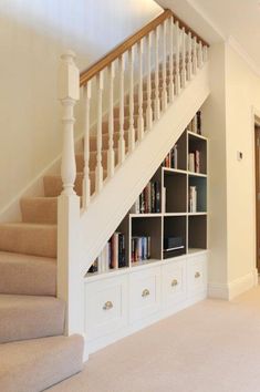 a staircase with bookshelves and drawers in a room that has carpet on the floor