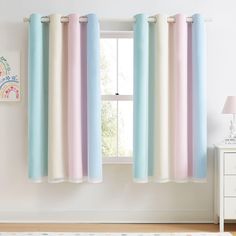 a room with a window, rug and curtains in pastel colors on the windowsill