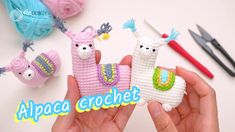 someone is holding two llamas made out of crochet