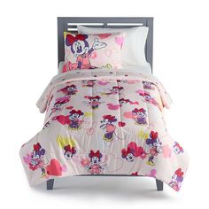 a bed with minnie mouse comforter and pillows