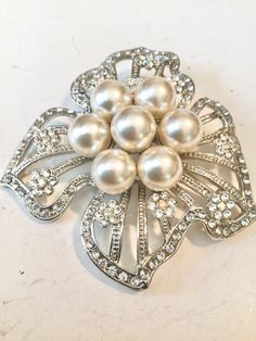 Elegant Silver Pearl Brooches, White Pearl Brooches For Formal Occasions, Formal White Pearl Brooches, Glamorous Silver Brooch For Wedding, White Pearl Brooches For Party, White Pearl Party Brooches, Elegant Crystal-embellished Brooches For Weddings, Elegant Crystal-embellished Wedding Brooches, Elegant Crystal Embellished Brooches For Wedding