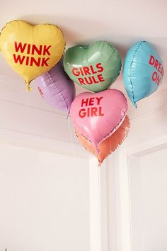 five heart shaped balloons that say wink wink, girls rules and hey girl on them