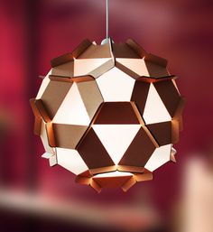 an unusual light fixture made out of cardboard boxes on a black background with geometric shapes