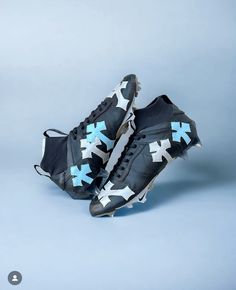 a pair of black and white shoes with blue crosses on them, against a gray background