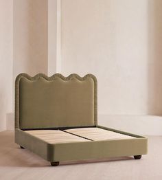 an upholstered bed frame with scalloped headboard