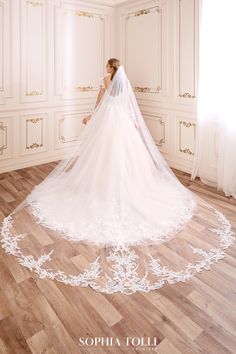 a woman in a wedding dress is standing on the floor with her veil over her head