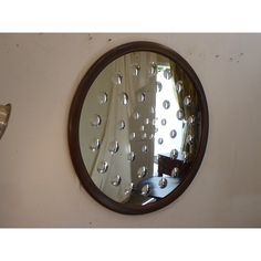 a round mirror hanging on the side of a wall