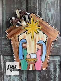 a wooden nativity scene hanging on a door