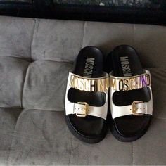 Perfect Brand New Condition. These Moschino Slides Are A Great Addition To Your Summer Wardrobe ! White Upper And Gold Hardware. Sz. 6.5 White Flat Platform Slides, White Platform Slides With Round Toe, Trendy White Leather Slides, Designer White Sandals With Leather Footbed, Designer White Sandals With Buckle Closure, Chic White Flat Slides, Trendy White Sandals With Leather Footbed, Designer White Round Toe Sandals, White Flat Slides With Buckle Closure