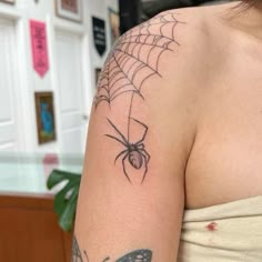 a woman with a spider tattoo on her arm