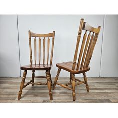 two wooden chairs sitting next to each other