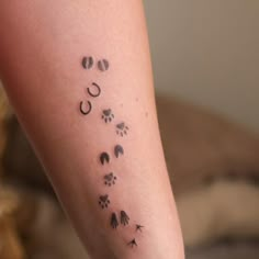 a person with a tattoo on their arm that has dog footprints and paw prints all over it