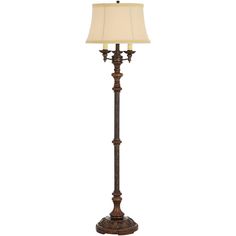 a floor lamp with a white shade on it's side and a brown base