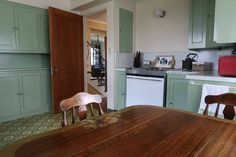 a wooden table sitting in the middle of a kitchen next to a stove top oven