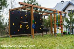 an outdoor play area with swings and climbing bars for children to climb on in the yard