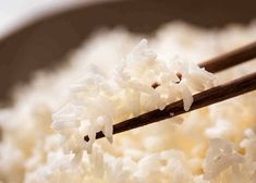 rice is being cooked with chopsticks in a bowl