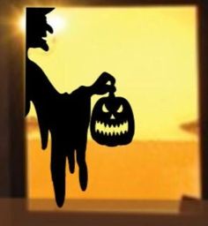 a silhouette of a person holding a jack - o'- lantern in front of an open window