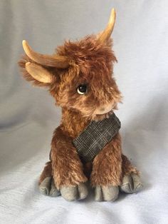 a stuffed animal that is sitting down on a white background with the head turned to look like a cow