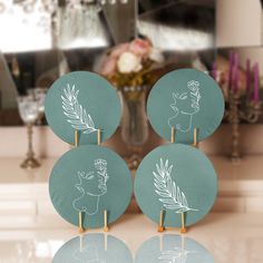 three green plates sitting on top of a counter next to a vase with flowers in it