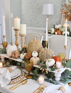 a dining room table with candles, pumpkins and other decorations on top of it