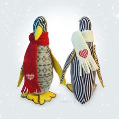 two stuffed penguins wearing scarves and scarfs