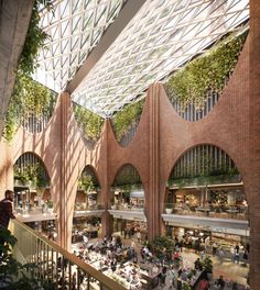 the interior of an indoor shopping mall with people walking and sitting on benches in it