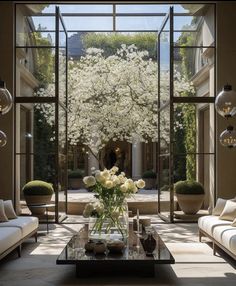 a living room filled with lots of furniture and flowers in vases on top of tables