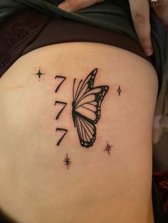 a woman's stomach with a butterfly tattoo on the side of her belly and stars around it