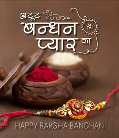 happy rasha bandhan in hindi with colorful powder and thread on wooden table