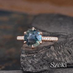 an engagement ring with a blue topazte surrounded by white diamonds on a rock