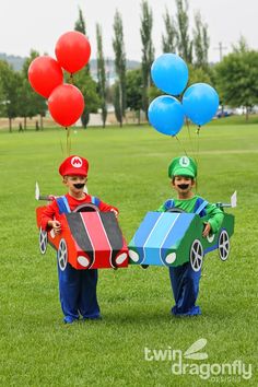 two young boys dressed up as mario and luigi in costumes with balloons attached to their heads