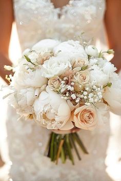 a bridal holding a bouquet of white flowers