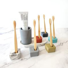 five toothbrushes in different shapes and sizes on a marble counter top with money