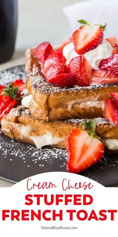 french toast topped with strawberries and whipped cream on a black plate next to a cup of coffee