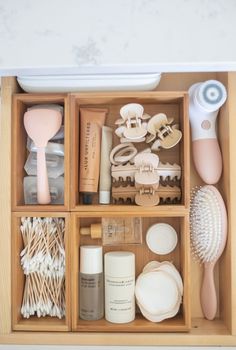 an open drawer containing various items such as hairbrushes, combs and other things