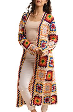 a woman wearing a multicolored crocheted cardigan