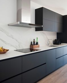 a modern kitchen with black cabinets and white counter tops is seen in this image from the front view