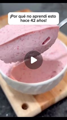 a spoon full of ice cream sitting on top of a wooden cutting board