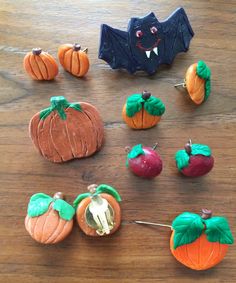 there are many pumpkins and other decorations on the wooden table with bats in the background