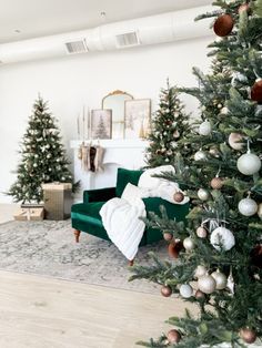 a living room decorated for christmas with green couches and ornaments on the tree's branches