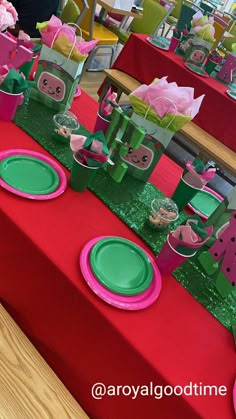 the table is set with pink and green decorations