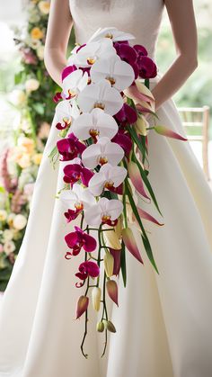 a woman in a wedding dress holding a bouquet of flowers