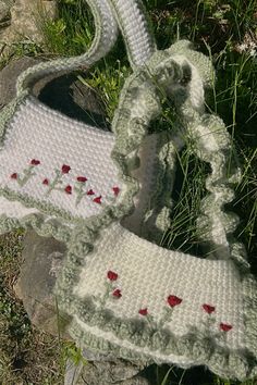 two crocheted purses sitting in the grass