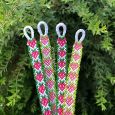 three pairs of scissors are made out of knitted material with white and pink hearts on them