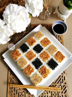 there is a square cake with black and white squares on it next to some flowers