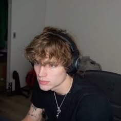 a young man wearing headphones sitting in front of a computer